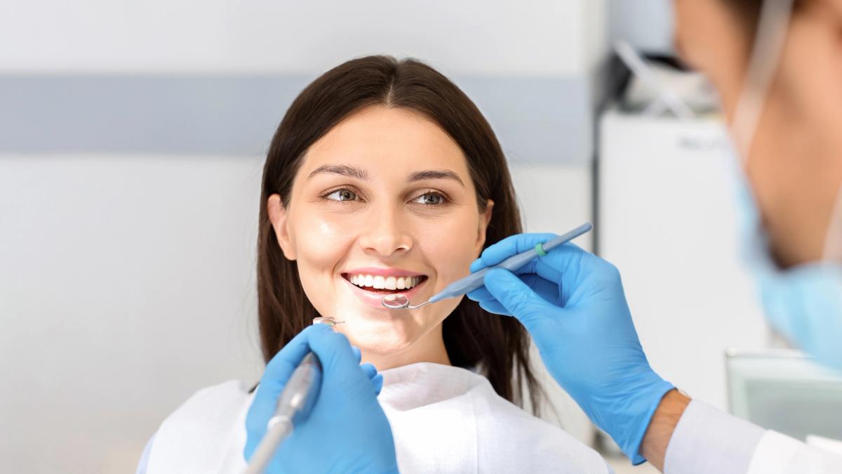 a woman is having her teeth examined by a dentist in a dental office .