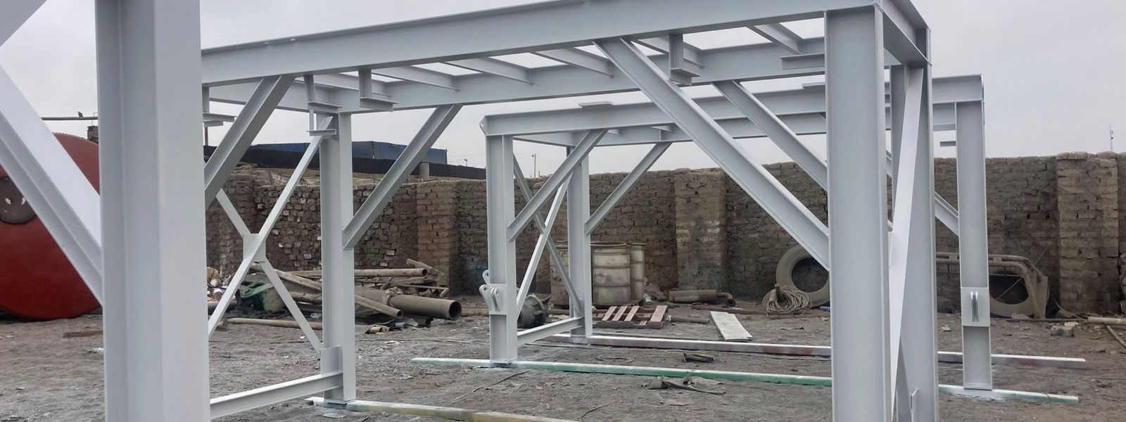 Pórticos de acero estructural imprimados en el patio de obra