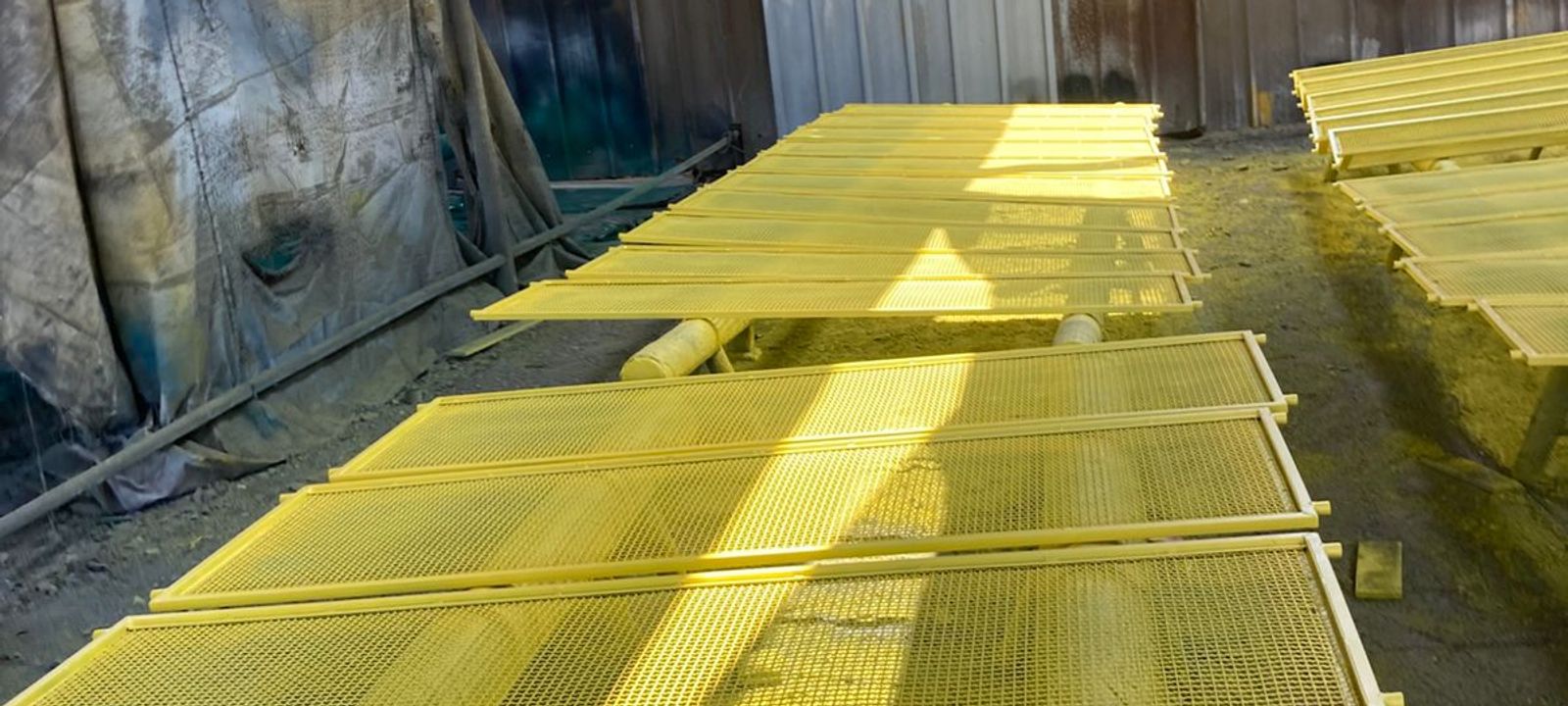 Paneles de malla vibratoria para equipos mineros, recién pintados de amarillo en el taller