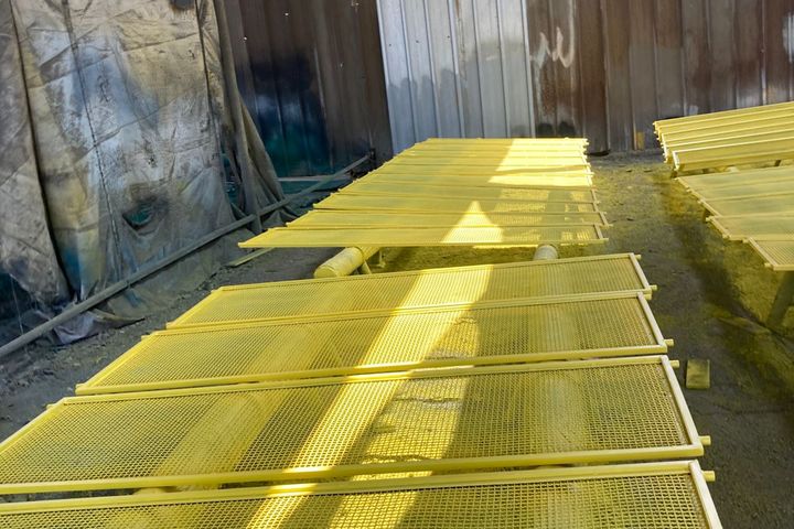 Paneles de malla vibratoria para equipos mineros, recién pintados de amarillo en el taller