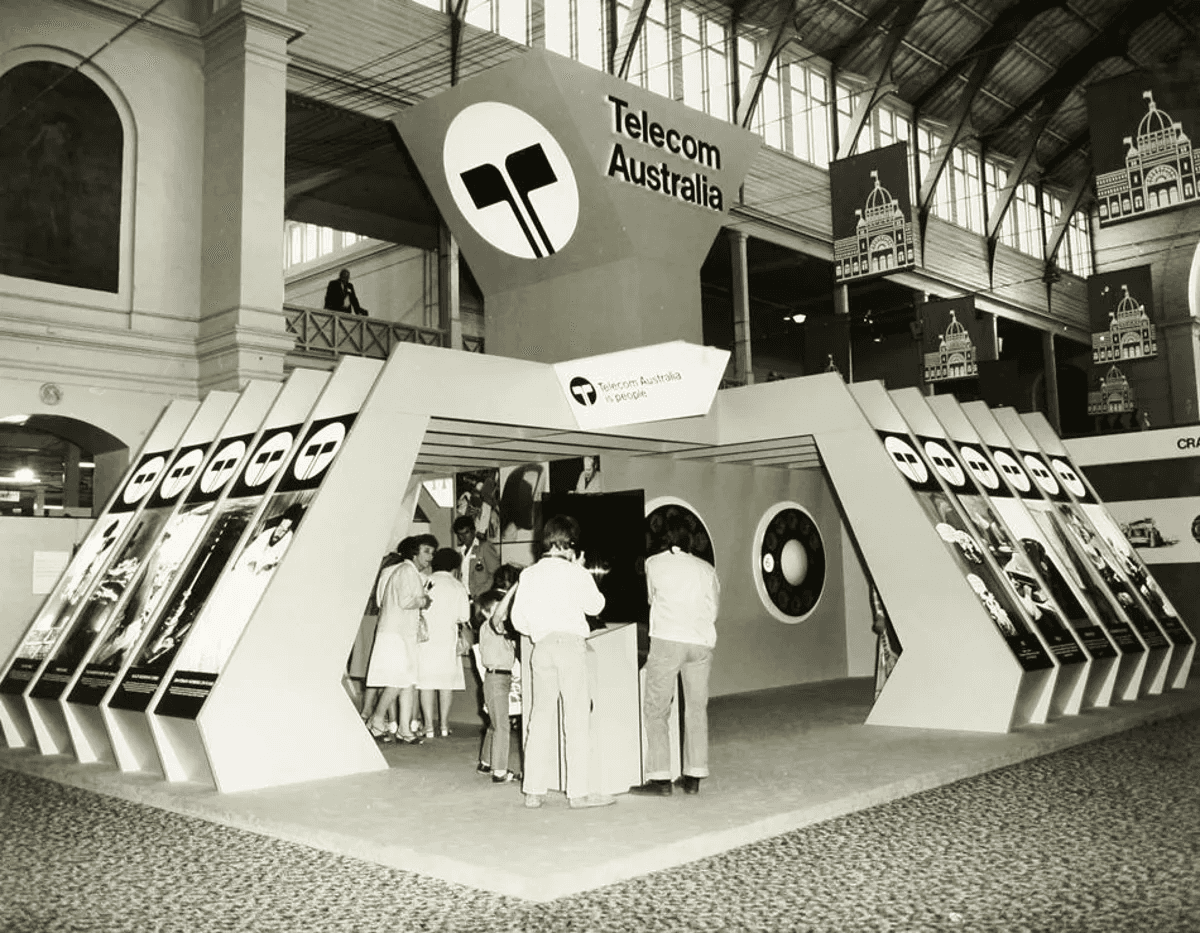 Vintage black-and-white photo of visitors at a Telecom Australia exhibition booth