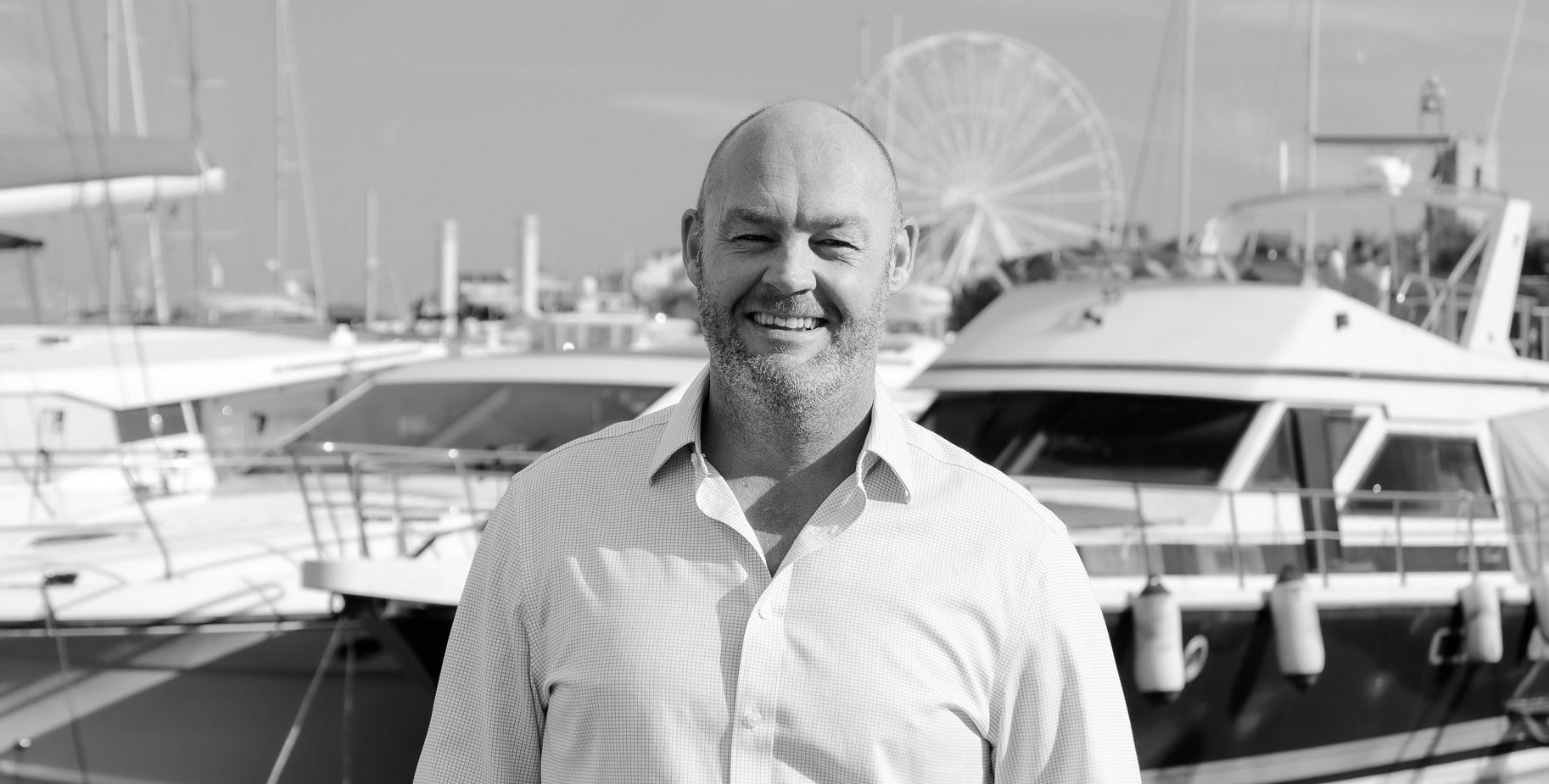 Portrait of Richard Higgins, Superyacht Broker at Northrop & Johnson, standing in a marina
