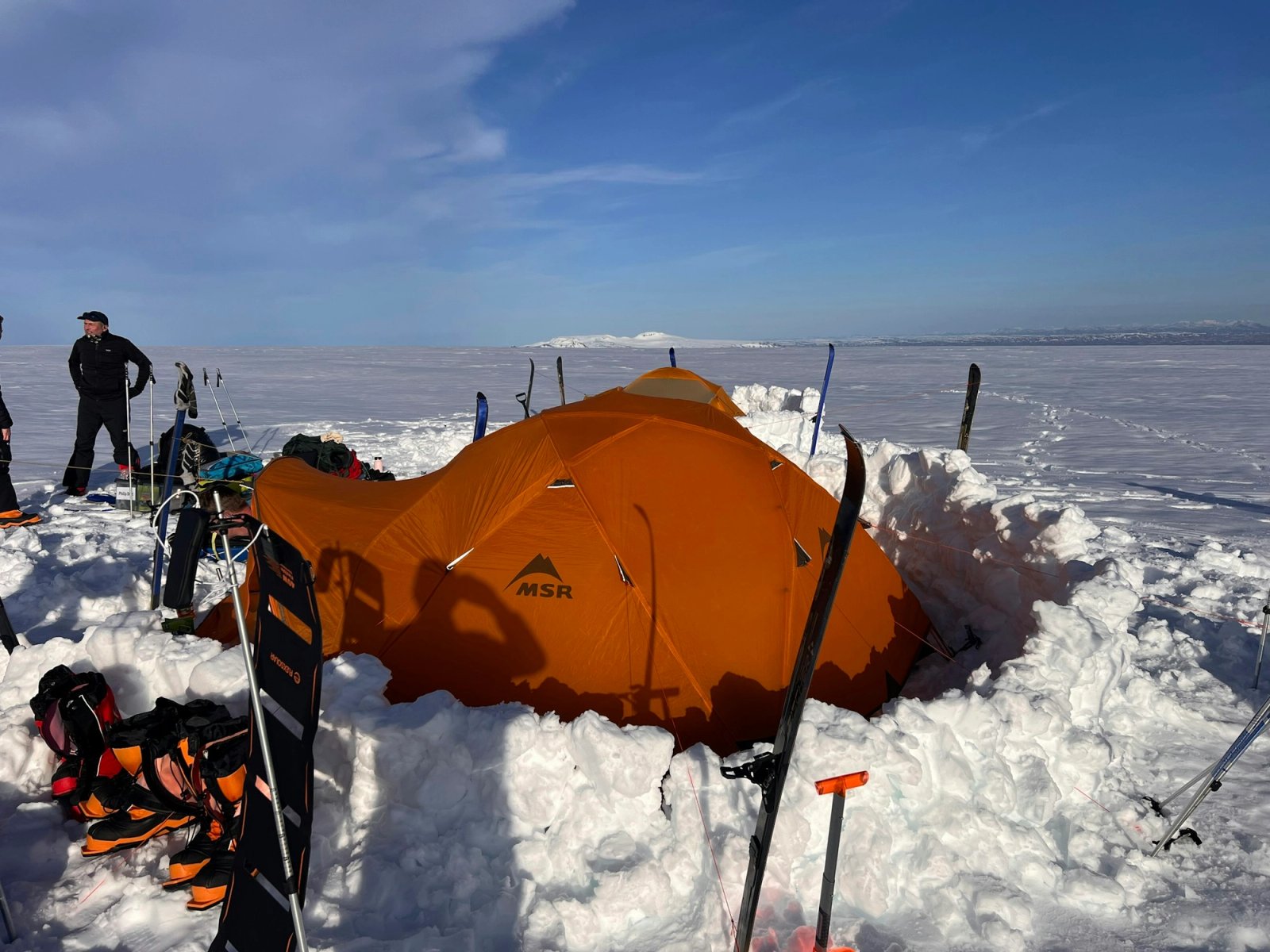 Expedition camp with an orange MSR tent dug into the snow on Iceland's Langjökull Glacier during Richard Higgins' Cancer Research UK trek