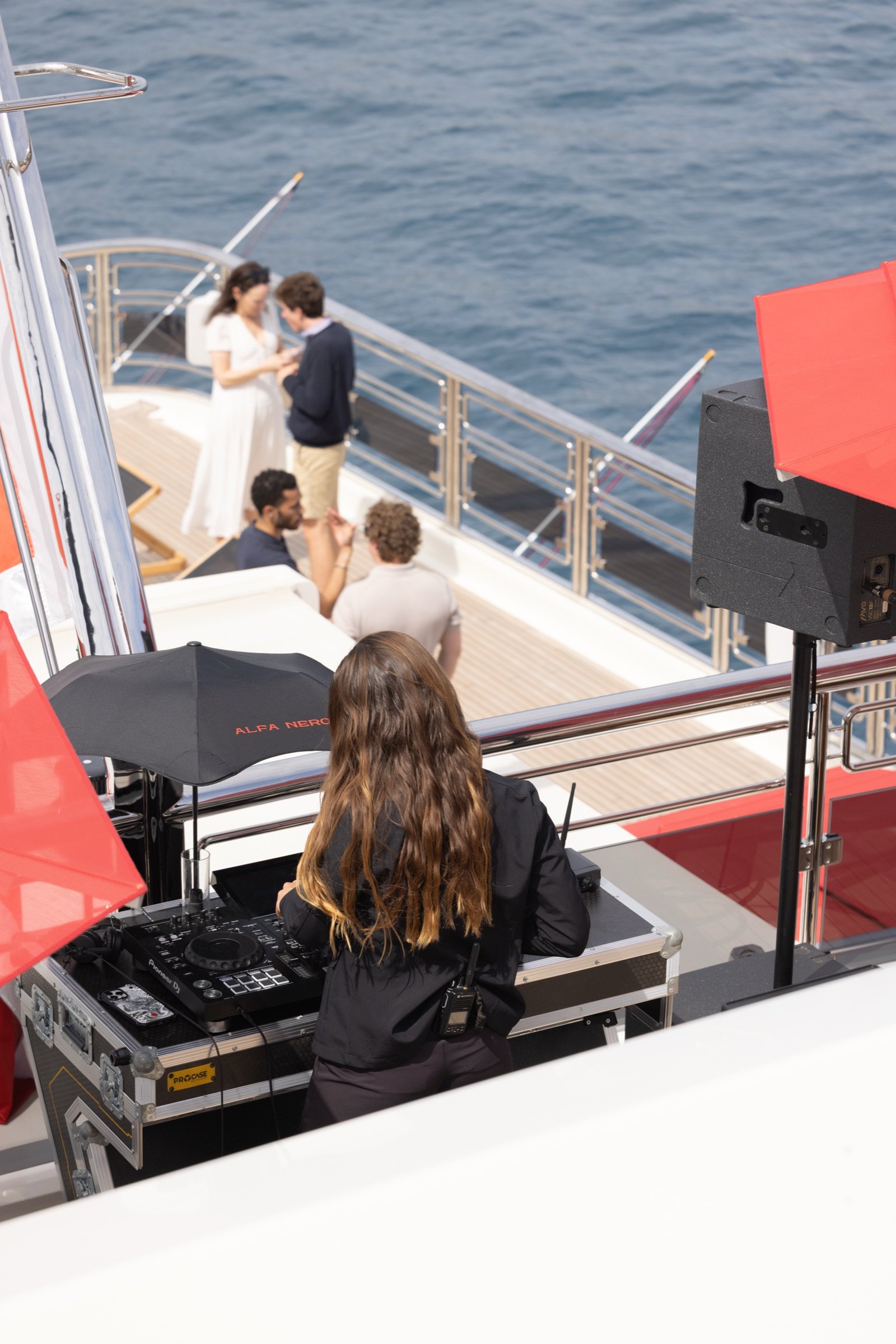 A DJ on deck beneath an ALFA NERO parasol during the Ocean Bottle evening
