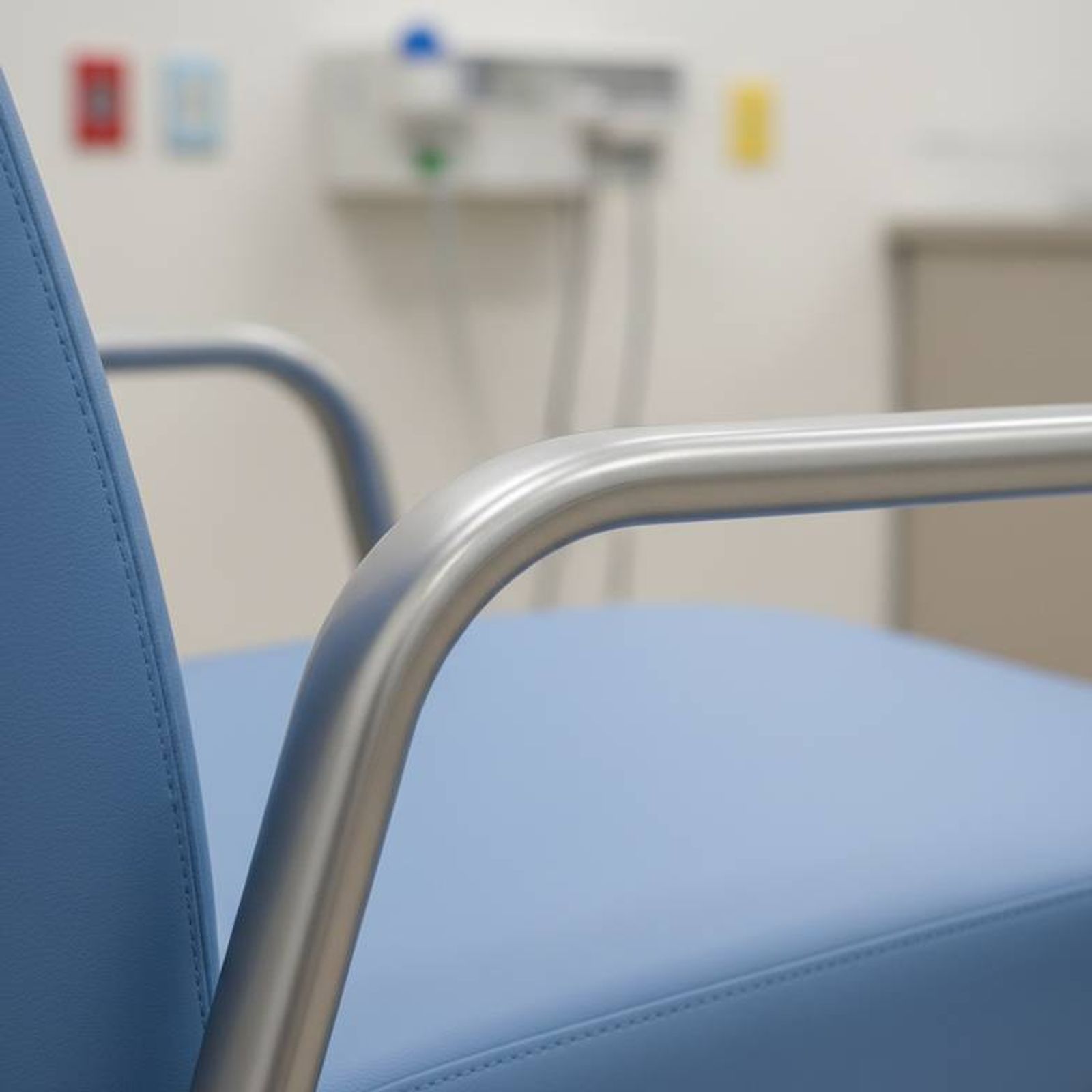 A close-up shot showing the texture of a patient chair's easy-to-clean surface and the sturdy connection of the armrest to the frame.