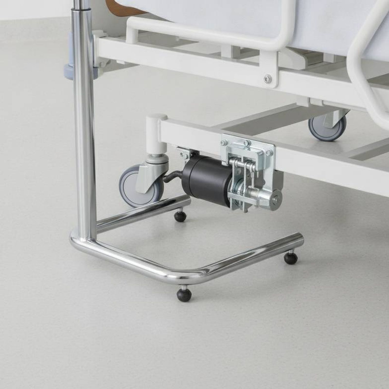 A close-up view showing the challenges of overbed table base clearance under an electric hospital bed