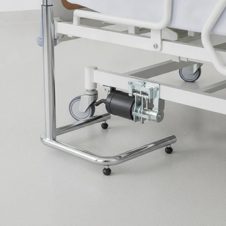 A close-up view showing the challenges of overbed table base clearance under an electric hospital bed