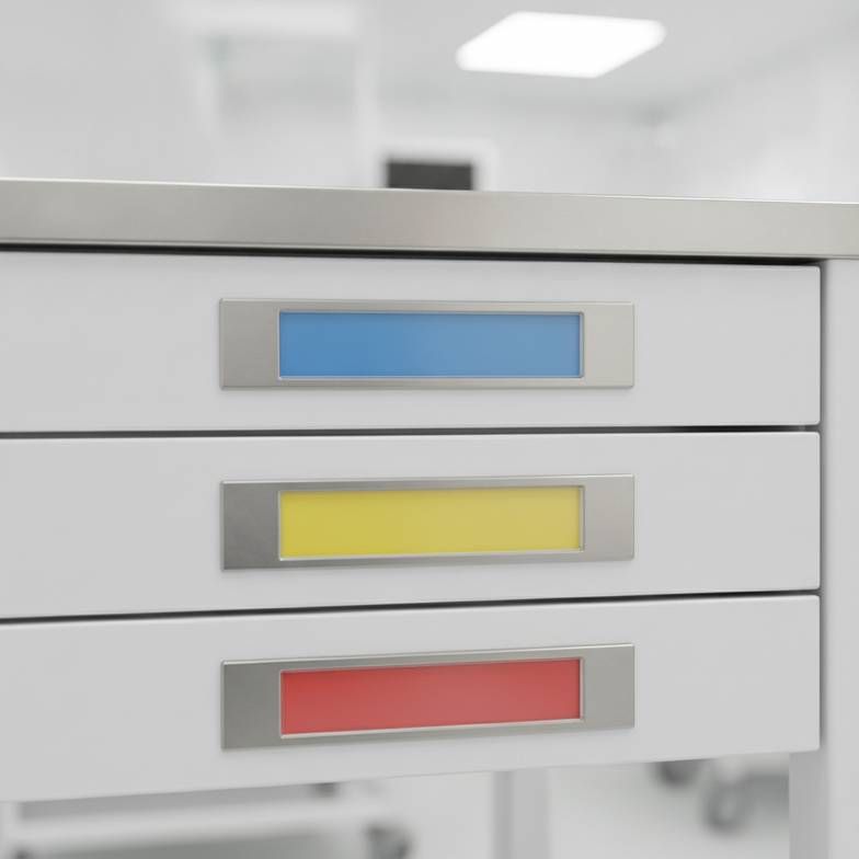 A close-up of several well-organized medical trolley label holders on a new treatment cart.