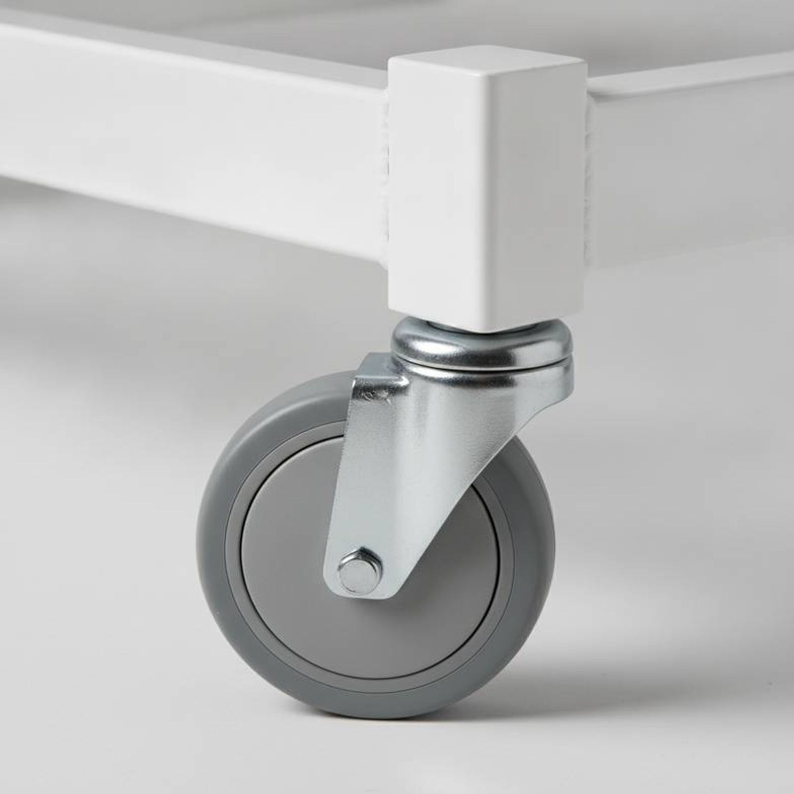 Close-up of a hospital bed's durable caster and steel weld, crucial for medical equipment distributors.