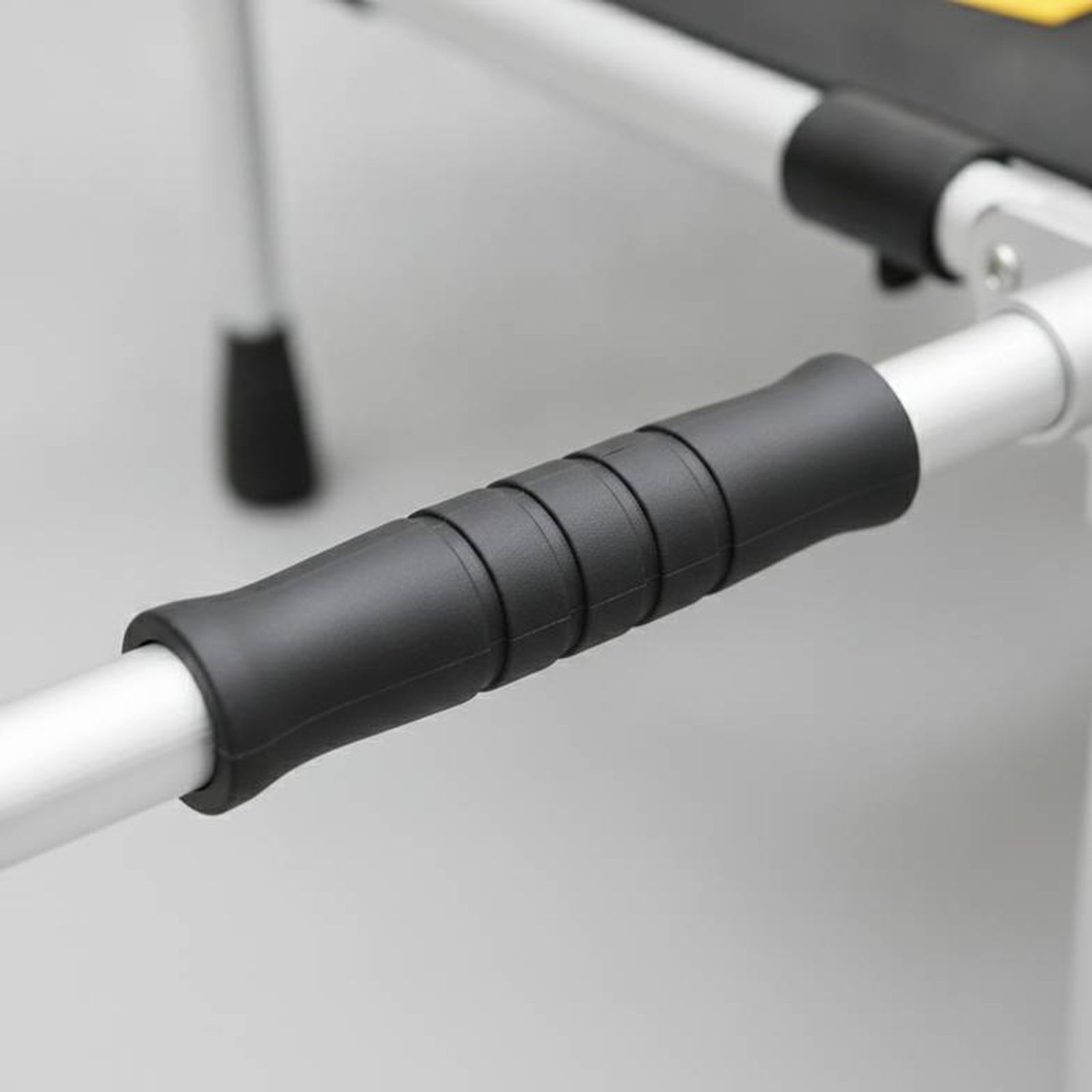 A close-up of an ergonomic, non-slip rubber handle on a portable folding stretcher