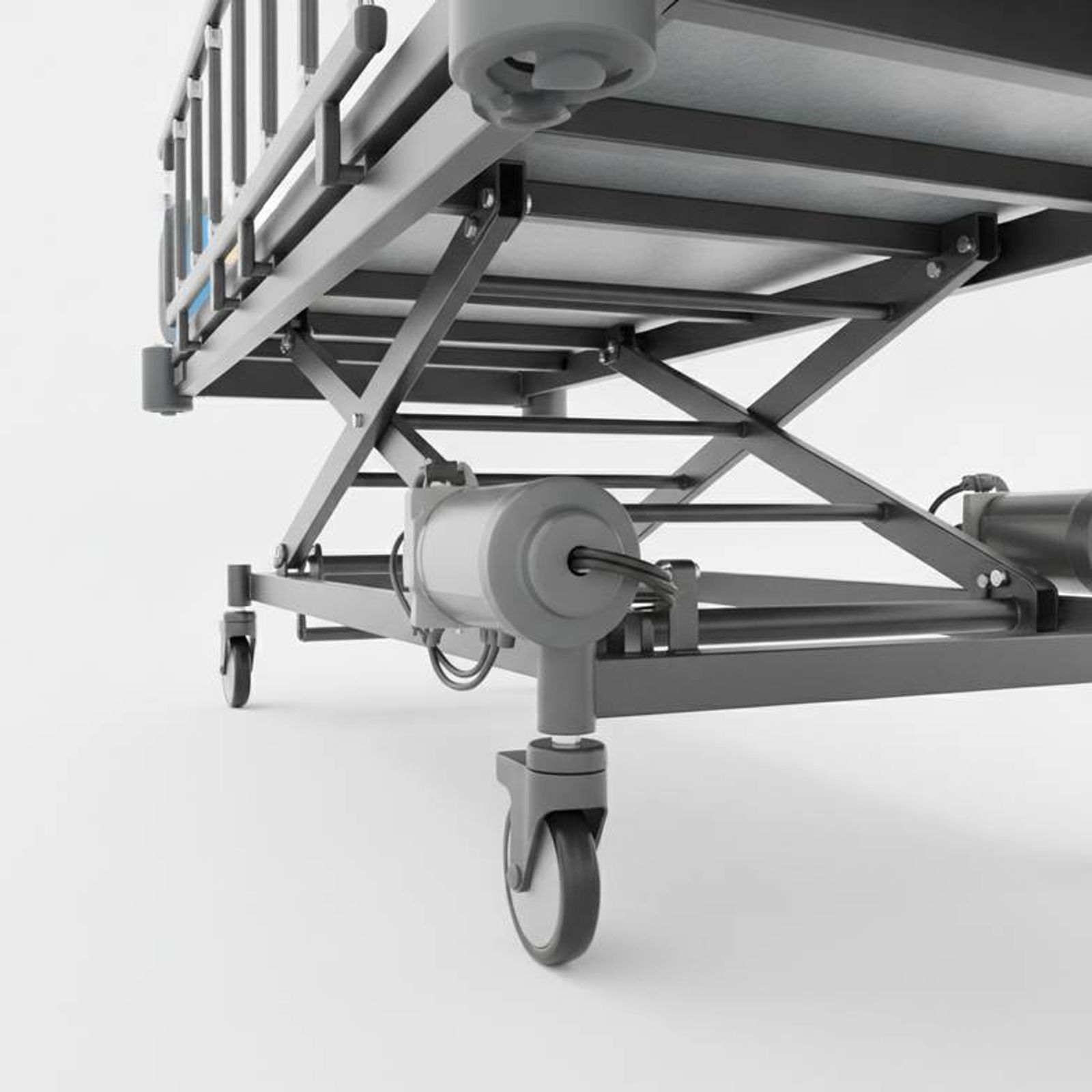 An electric hospital bed in its lowest position, highlighting the limited under-bed clearance near the actuators.