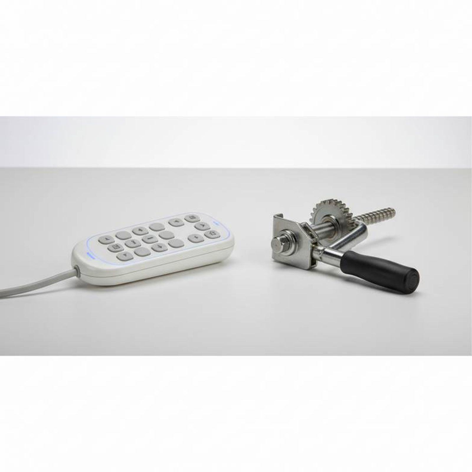 A close-up showing the difference between a manual crank handle and an electric control handset for a hospital bed.