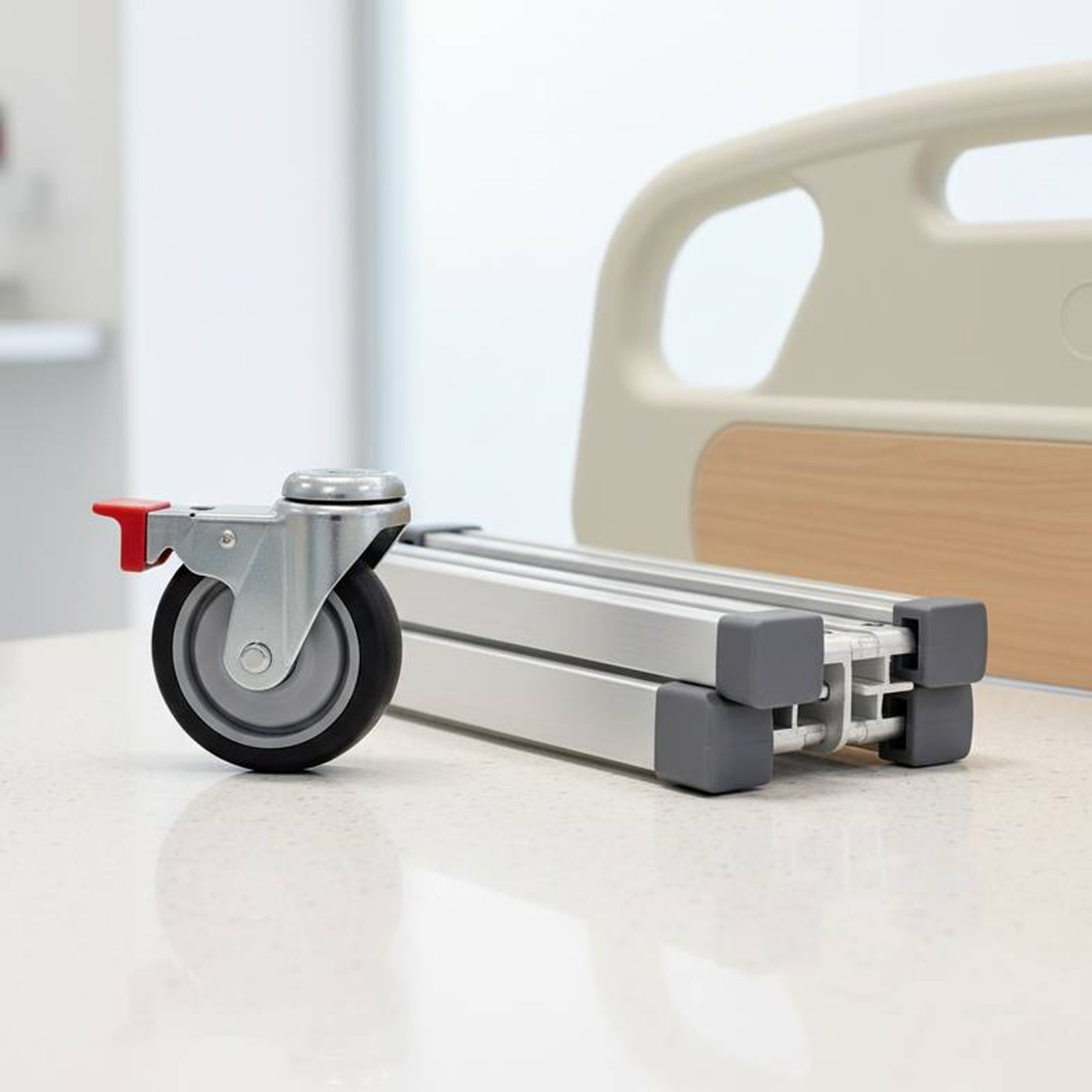 A detailed shot showing different hospital bed components like a caster with a brake, a side rail mechanism, and a headboard, highlighting configuration options.