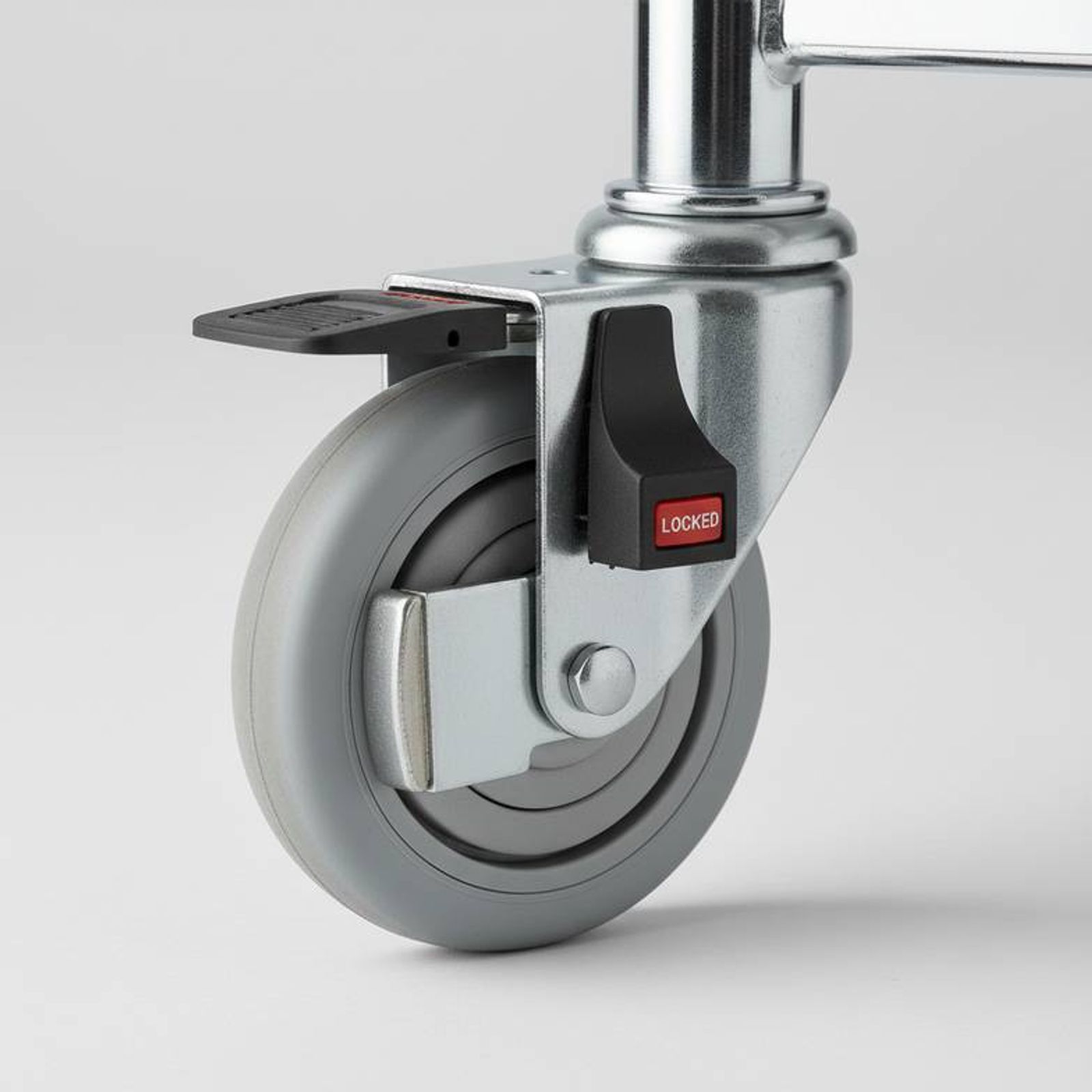 A close-up of a medical trolley caster with the locking mechanism engaged.