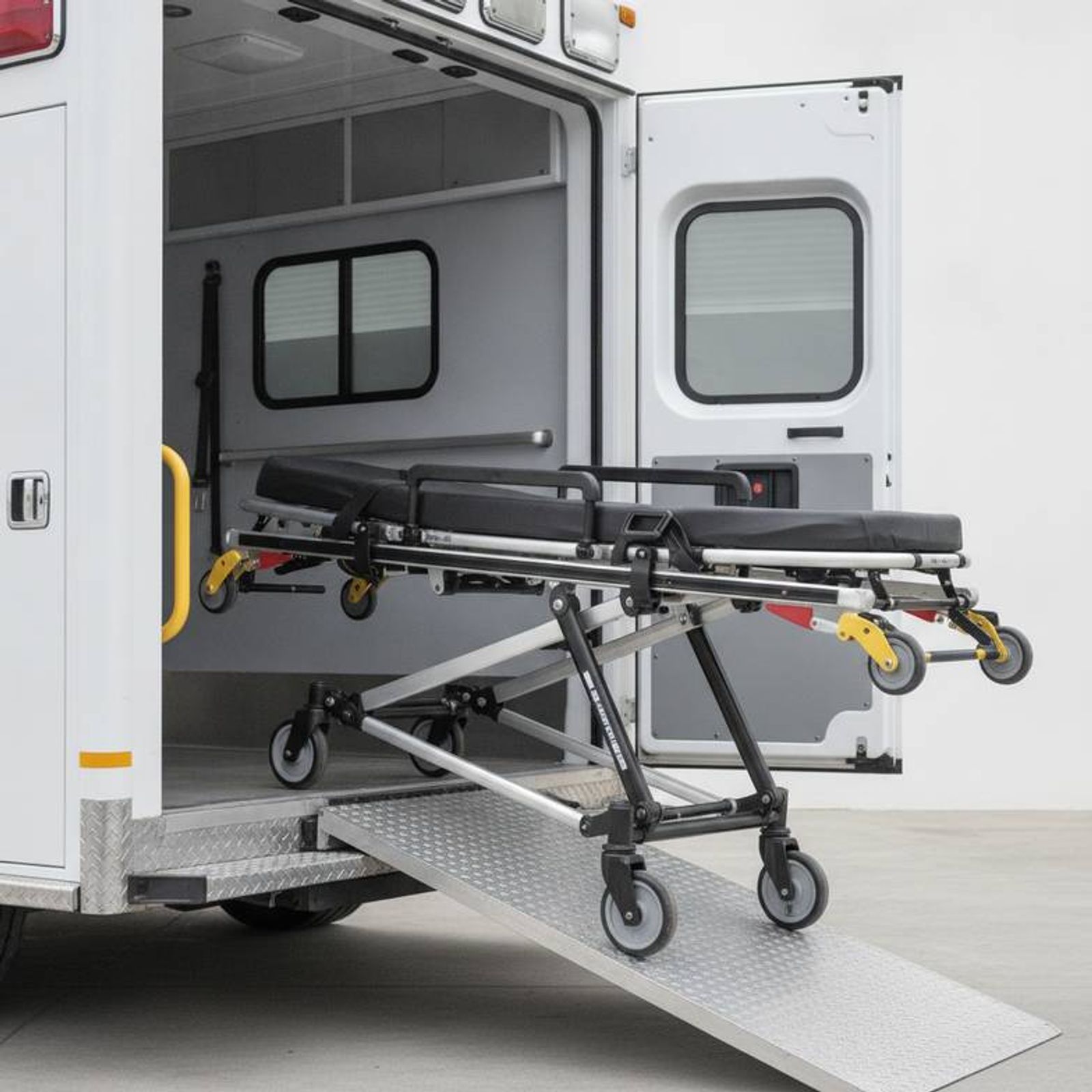 An ambulance stretcher cot being loaded into an emergency vehicle