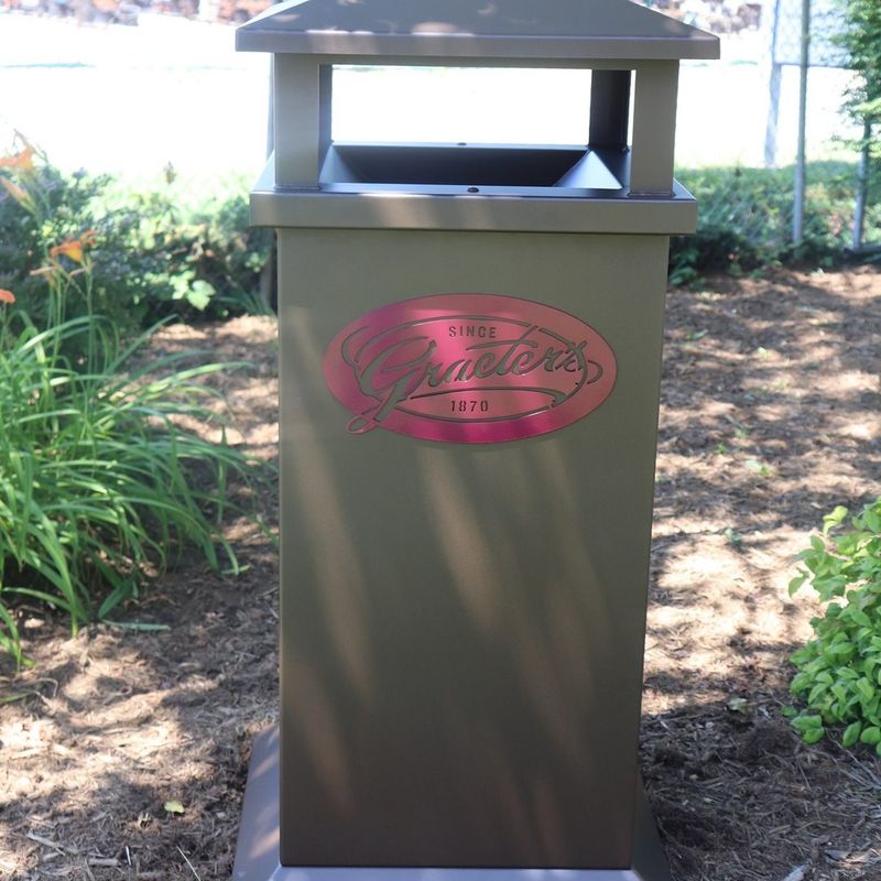 Trash Receptacles
TR-1920-32 Custom 
52.5” H x 25.25” Square
Body-Cappuccino Powder Coat 
Logo- Claret-Violet RAL 4004 Powder Coat