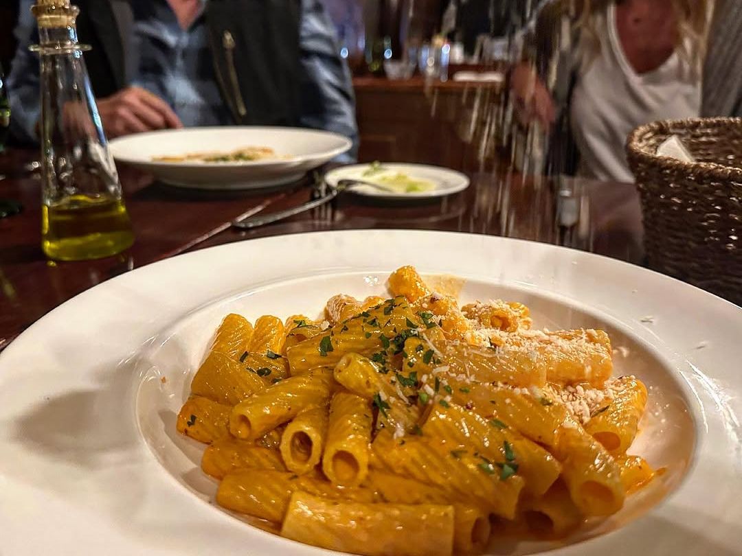 Classic rigatoni pasta tossed in a rich tomato cream sauce and finished with parmesan cheese. A comforting Italian plate served in a cozy, authentic setting.