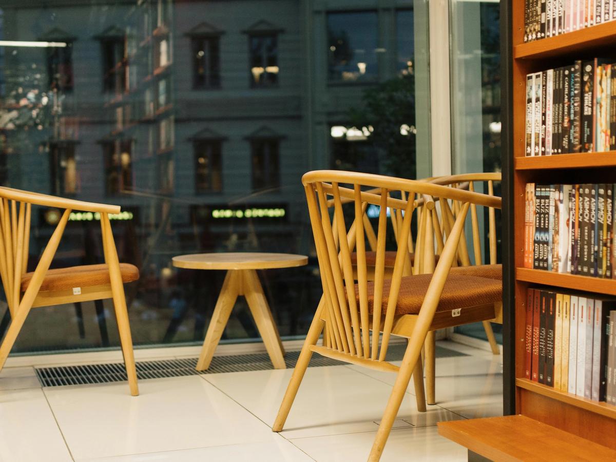Bookstore tour featuring a cozy reading corner with wooden chairs and shelves lined with books.