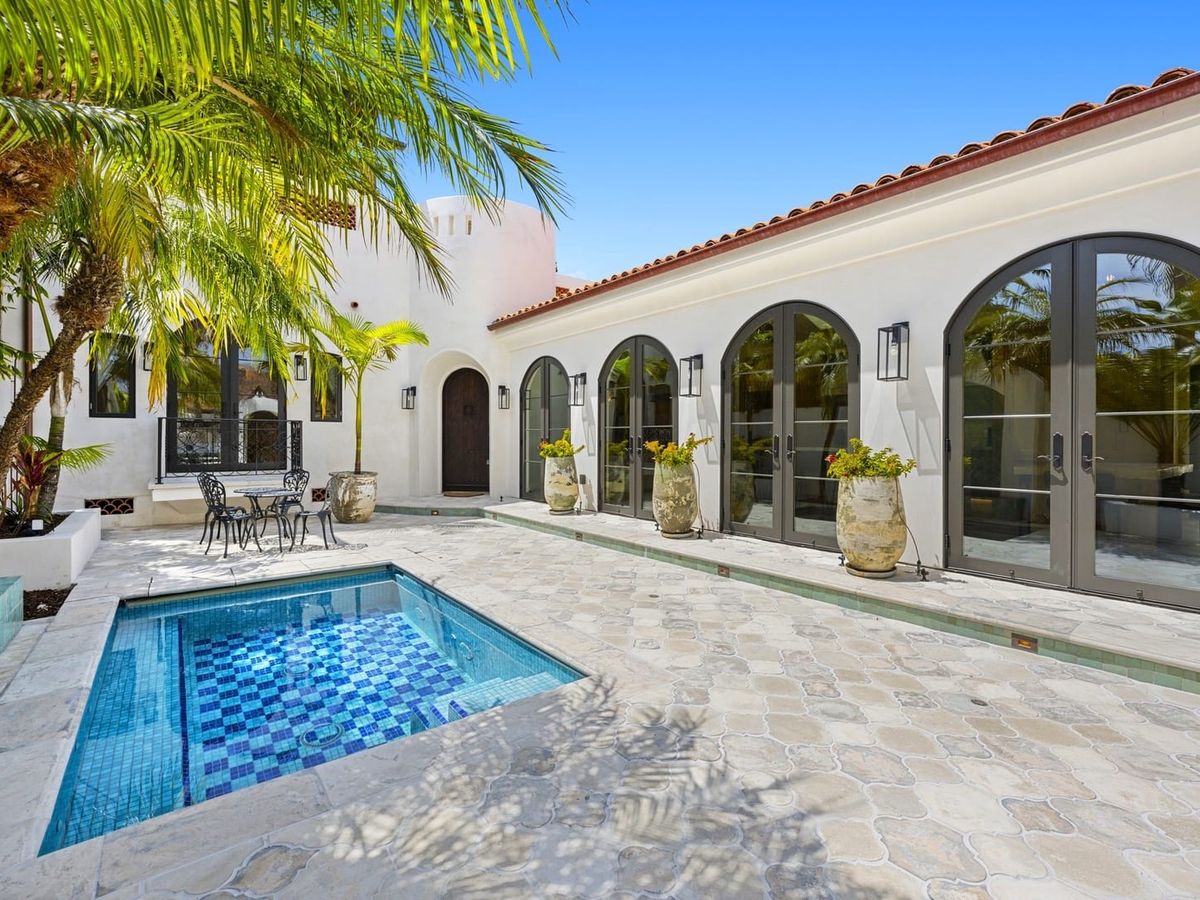 Step into a Spanish-style villa with arched doors, a mosaic-tiled spa, and a peaceful courtyard. Puertas Del Cielo offers luxury and charm, with palm trees swaying under the California sun.