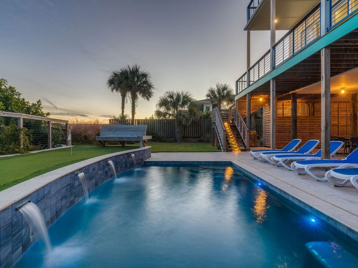 Private pool with water falling into the pool and lounge chairs by the poolside