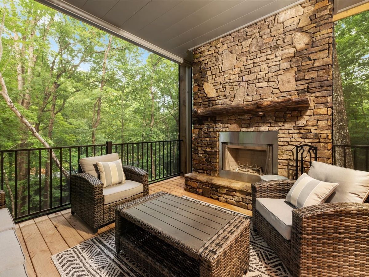 Creek Songs in Blue Ridge, GA blends modern style with rustic charm. Enjoy a private sauna, fire pit, shuffleboard, and a relaxing hot tub surrounded by forest views.