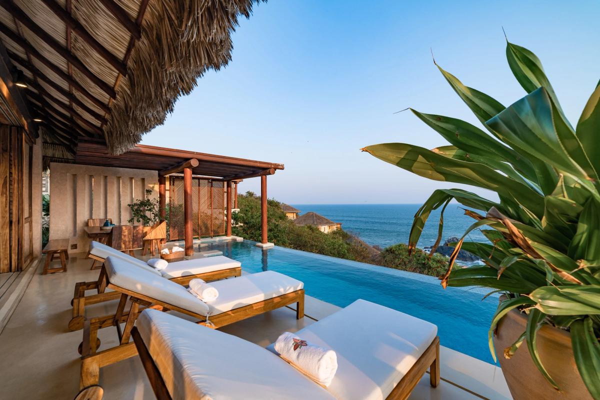 Lounge chairs looking out to the private pool and sea.