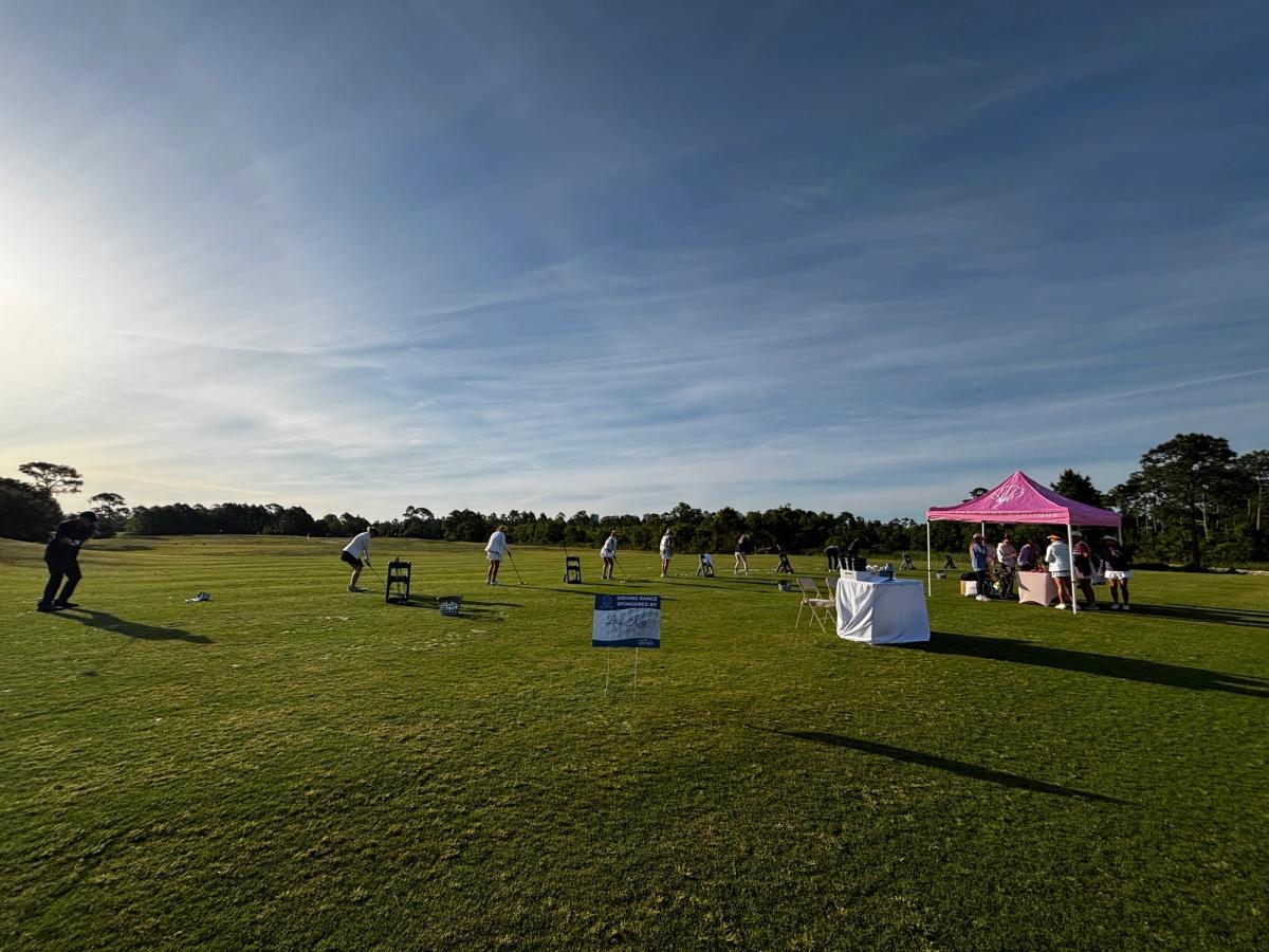The lush fairways and sand traps of Lost Key Golf Club sit beside a tall resort building, offering golfers a championship course surrounded by natural beauty.