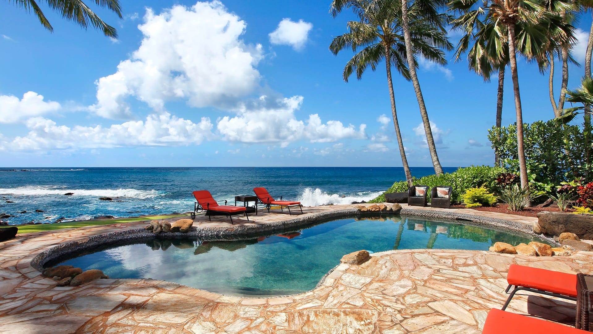 This oceanfront pool in Kauai sits just steps from the rocky shoreline and crashing waves. Palm trees frame the view, creating a true island feel. Kauai Kai is perfect for guests who want nonstop ocean scenery.