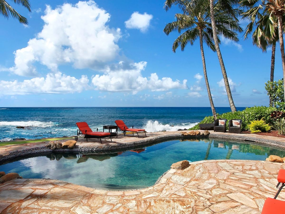 This oceanfront pool in Kauai sits just steps from the rocky shoreline and crashing waves. Palm trees frame the view, creating a true island feel. Kauai Kai is perfect for guests who want nonstop ocean scenery.