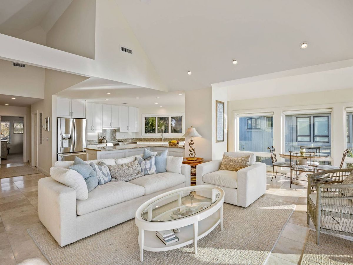 Alt text: A beautifully updated villa with stylish interiors, cozy seating areas, and a modern kitchen. Large windows let in natural light, offering calming views of the surrounding scenery. Ideal for small families or groups seeking a peaceful island escape.