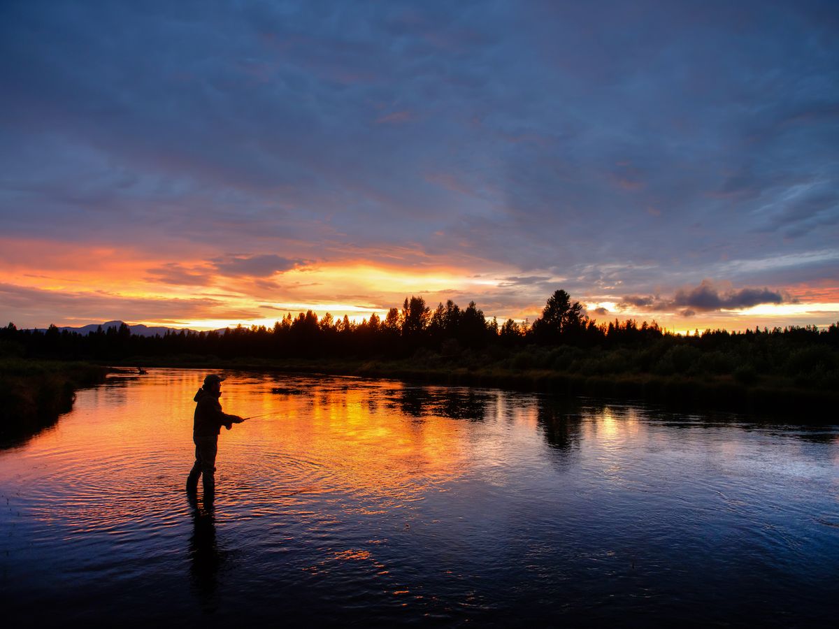 Person Fly Fishing in West Yellowstone, Montana at Sunset