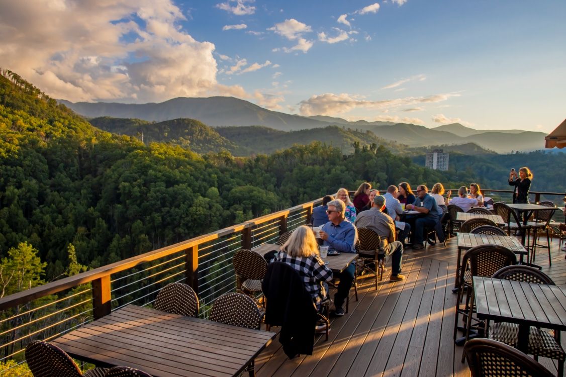 Guests take in the colorful sunset views from the top of the AnaVista Tower surrounded by mountain scenery and glowing evening skies. This scenic lookout offers one of the best panoramic views for visitors exploring the Smoky Mountains and nearby attractions.