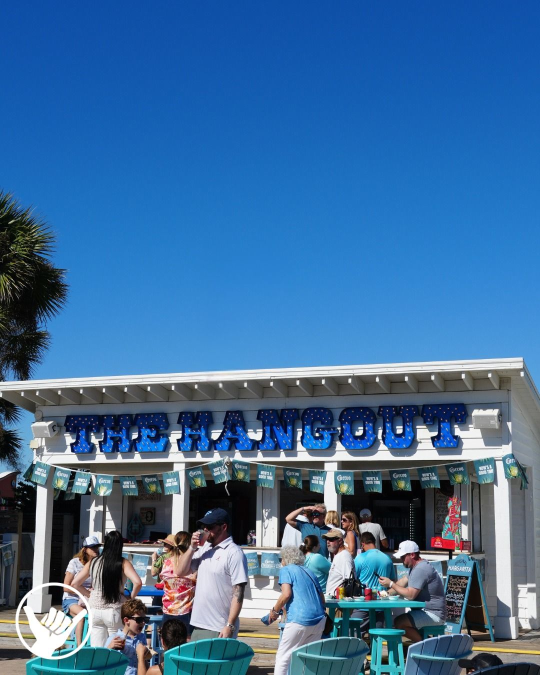 The bright blue sign of The Hangout stands out under clear skies in Gulf Shores. Families gather outside to enjoy beachside dining, live music, and fun energy. It’s a must-visit restaurant near the beach in Gulf Shore