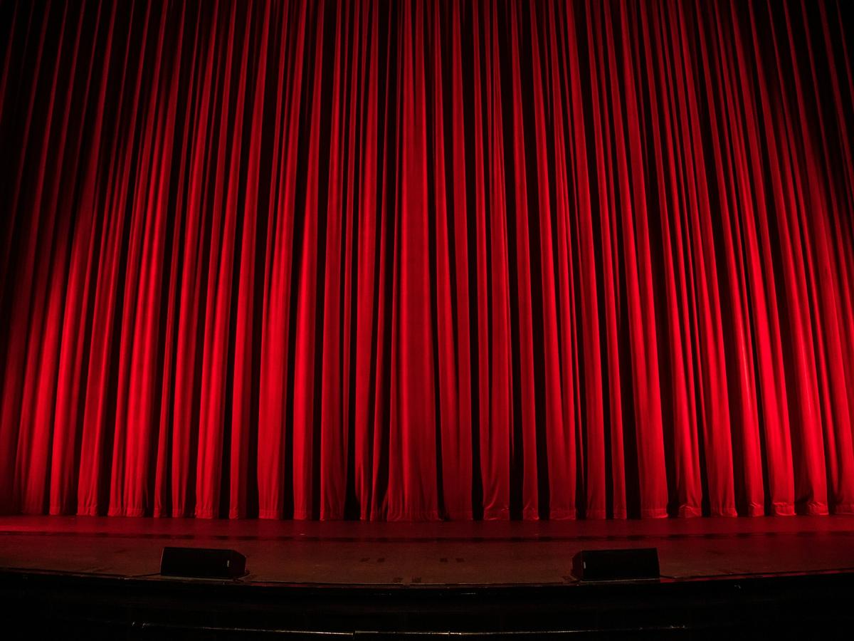 Velvet red curtain at theatre with lights shining on it