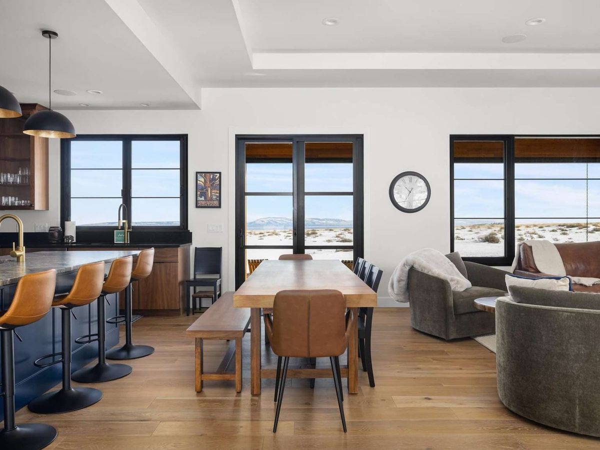 This modern mountain getaway blends sleek finishes with wide-open views of snowy plains. The open kitchen and living space make it ideal for group meals, board games, or stargazing from the window.