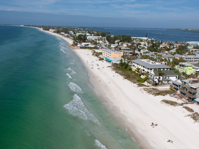 Stunning view of Coquina Beach with soft white sand and calm emerald waves—a quiet spot perfect for a beach day.