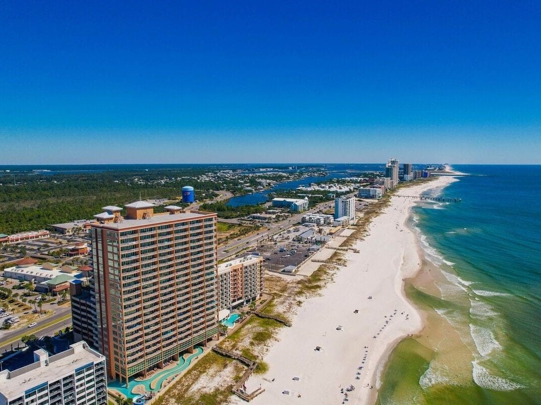Aerial view of high-rise beachfront condos and turquoise waters along Gulf Shores. Great for spur-of-the-moment trips where the beach is just steps away.