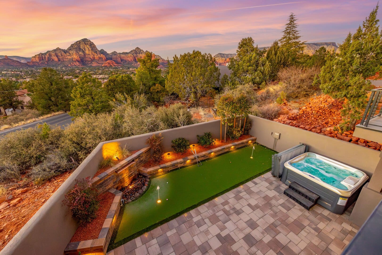 Stunning Sedona retreat with a private putting green, hot tub, and breathtaking red rock views at sunset.