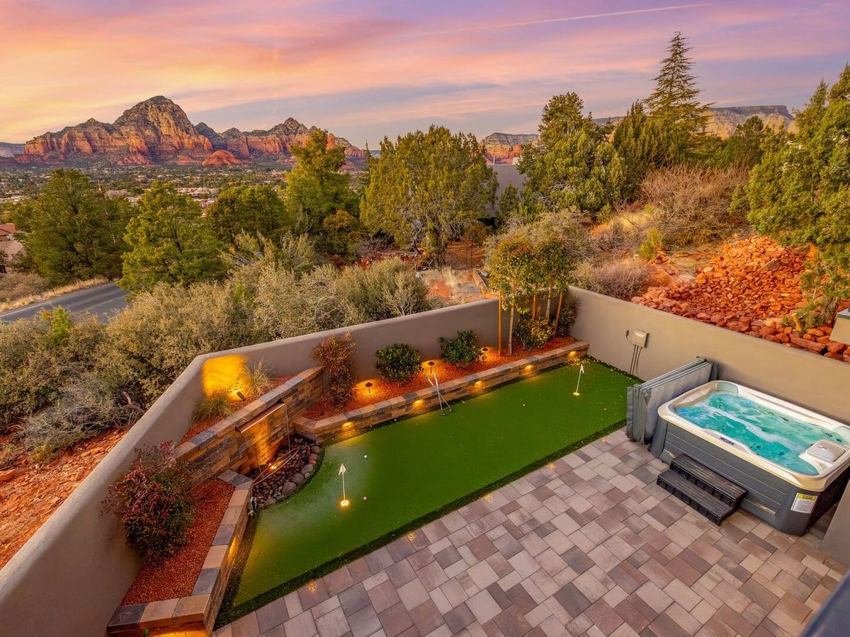 Stunning Sedona retreat with a private putting green, hot tub, and breathtaking red rock views at sunset.