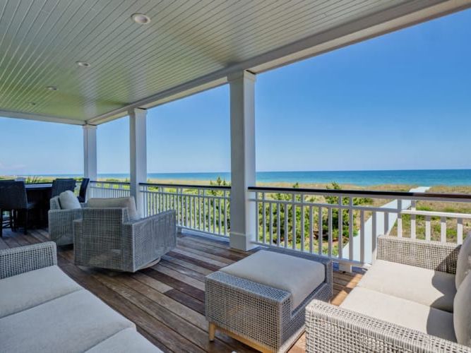 Soak up endless ocean views from this breezy covered porch with cozy outdoor seating. Inside, modern coastal design meets comfort, making it easy to unwind with friends and family.