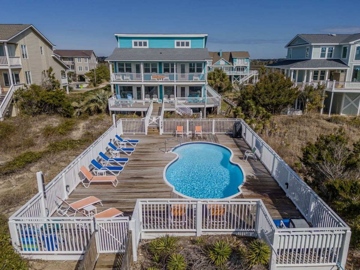 Large Holden Beach home with a private pool, multiple balconies, and a boardwalk to the beach. Pet-friendly and perfect for big families, this house blends beach access with modern outdoor lounging.