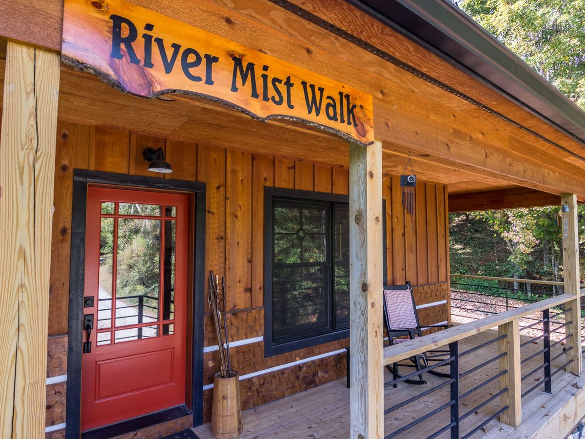 Exterior of cabin rental with red door and sign above door