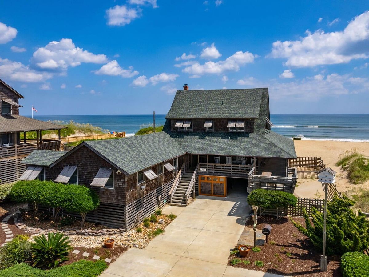 A charming beachfront home sits just steps from the sand, with ocean waves rolling in behind it. This cozy vacation rental offers room for the whole family and unbeatable sea views right from the porch.