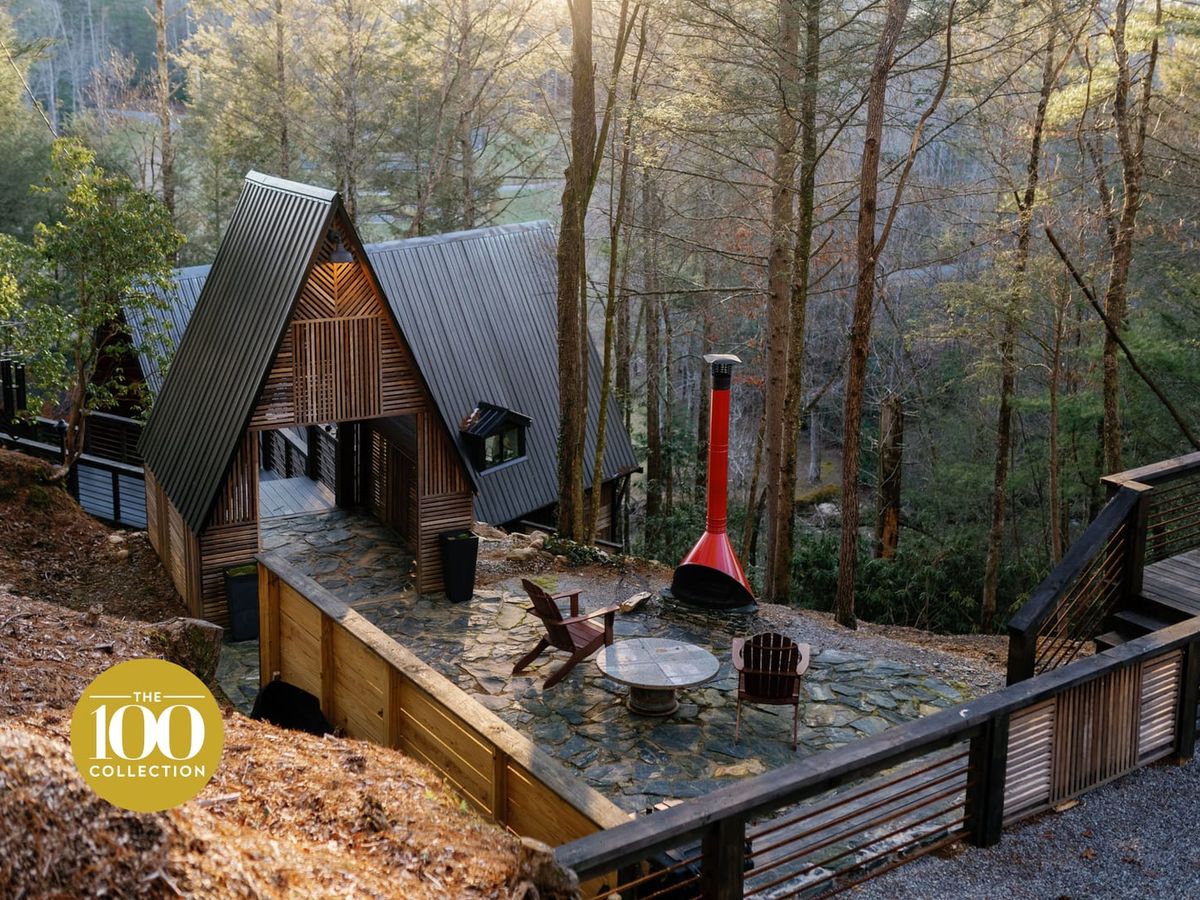 A fram cabin with outdoor firepit and forest trees in the background