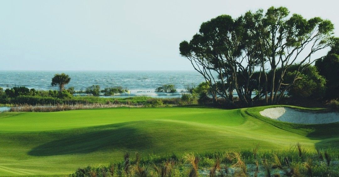 A scenic view of The Ocean Course with rolling green fairways set against the Atlantic Ocean. This coastal golf course is known for ocean breezes, natural dunes, and stunning seaside views that make every round memorable.