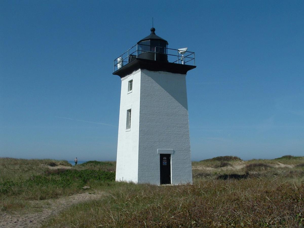 A small white lighthouse stands quietly among grassy dunes along the Cape Cod coastline. The surrounding trails are popular for hiking and enjoying ocean views. It is a peaceful place where nature and maritime history meet.
