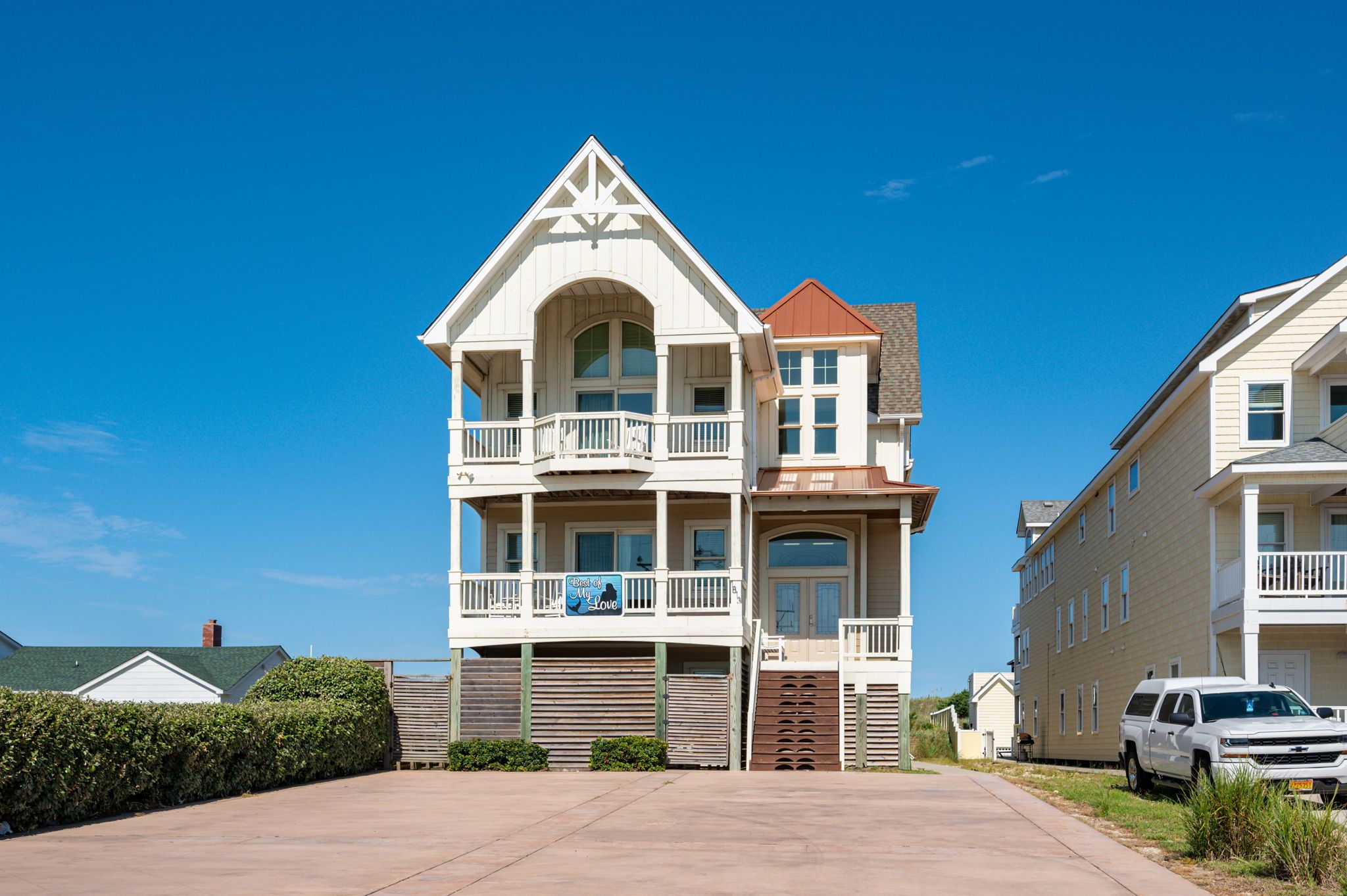 White house in Outer Banks with bushes next to home