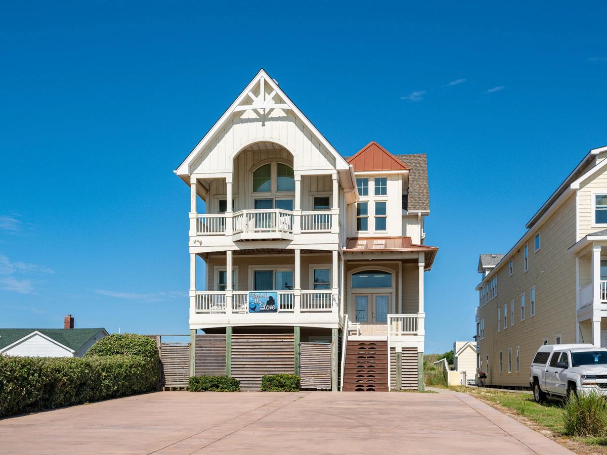 White house in Outer Banks with bushes next to home