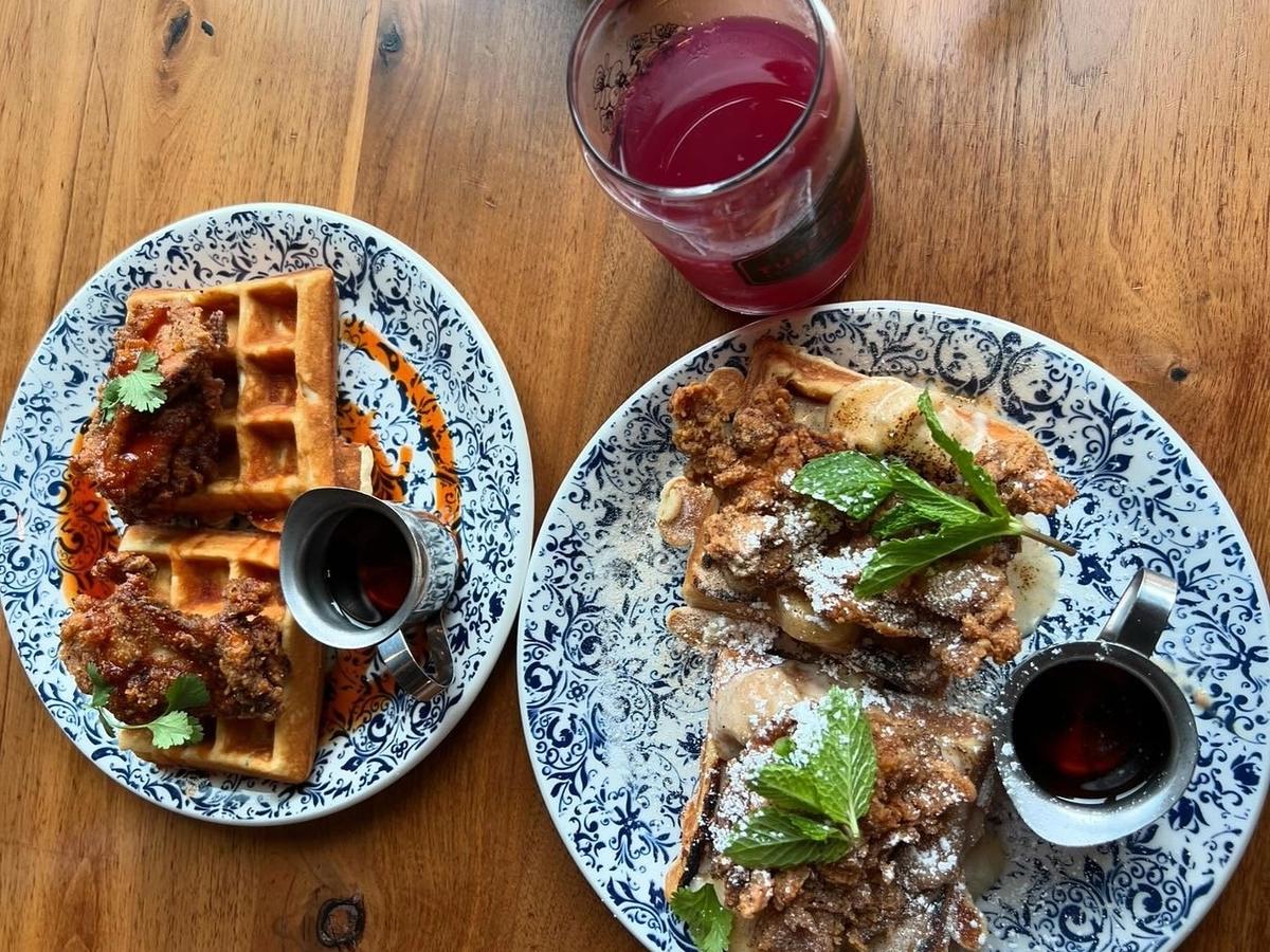 Delicious Southern comfort food at Tupelo Honey Cafe, with vibrant plates of fried chicken, waffles, and fresh, locally inspired sides served in a cozy, casual setting