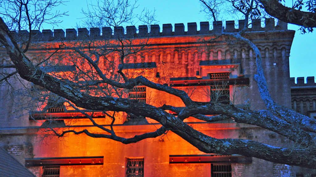 Charleston’s Old City Jail glows with an eerie orange light, setting the mood for ghost tours and haunted history walks. Its historic walls and barred windows make it one of the city’s most chilling landmarks.
